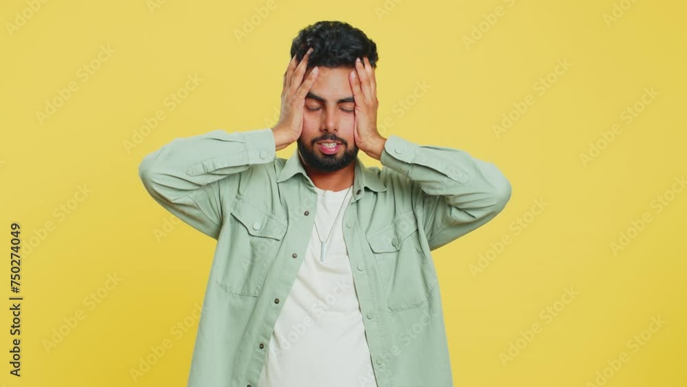 Irritated angry Indian man screams from stress tension problems feels horror hopelessness fear surprise shock expresses rage nervous, quarrel. Arabian young guy isolated on yellow studio background Irritated angry Indian man screams from stress tension problems feels horror hopelessness fear surprise shock expresses rage nervous, quarrel. Arabian young guy isolated on yellow studio background