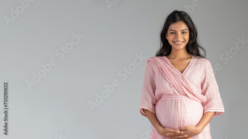 Indian pregnant woman with pregnancy belly, in soft pink clothes photo