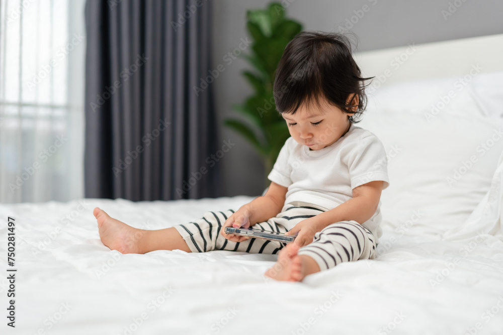 toddler baby using and watching smartphone on bed toddler baby using and watching smartphone on bed