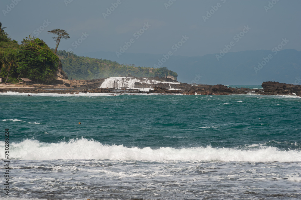 Rocas con olas y cascadas de Karang Taraje foto desde karang Beurem, Sawarna, Lebak Regency, Banten, Java,, Indonesia