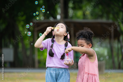 Girls in the park with blowing air bubble  Surrounded by greenery and nature