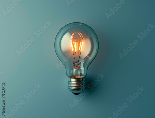 A light bulb, shining on a blue background, is presented, showcasing vintage modernism, eco-friendly craftsmanship, clever wit, and colors of light cyan and gray. photo
