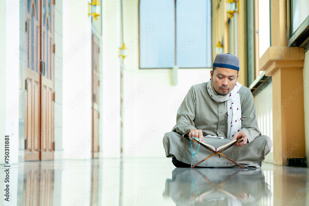 Ramadan, Quran, Islam, An Asian Muslim man is sitting and reading the Quran. The peace in the mosque makes it an energetic atmosphere of faith, with copy space. Ramadan, Quran, Islam, An Asian Muslim man is sitting and reading the Quran. The peace in the mosque makes it an energetic atmosphere of faith, with copy space.