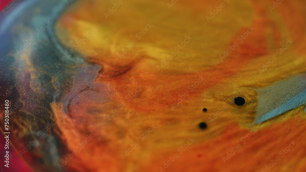 Glitter fluid splash. Oil blob. Ink water mix. Blur golden orange red blue color sparkling particles texture paint blend bubble flow abstract art background.