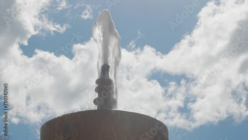 STONE FOUNTAIN WITH A JET OF WATER ON A CLOUDY DAY photo