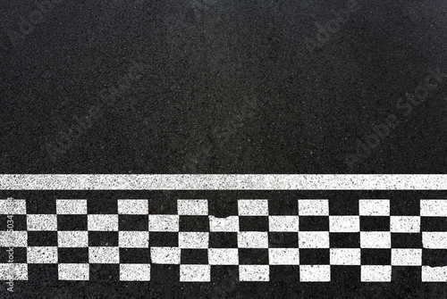 Damier noir et blanc sur asphalte, ligne de départ de courses automobiles  © Unclesam