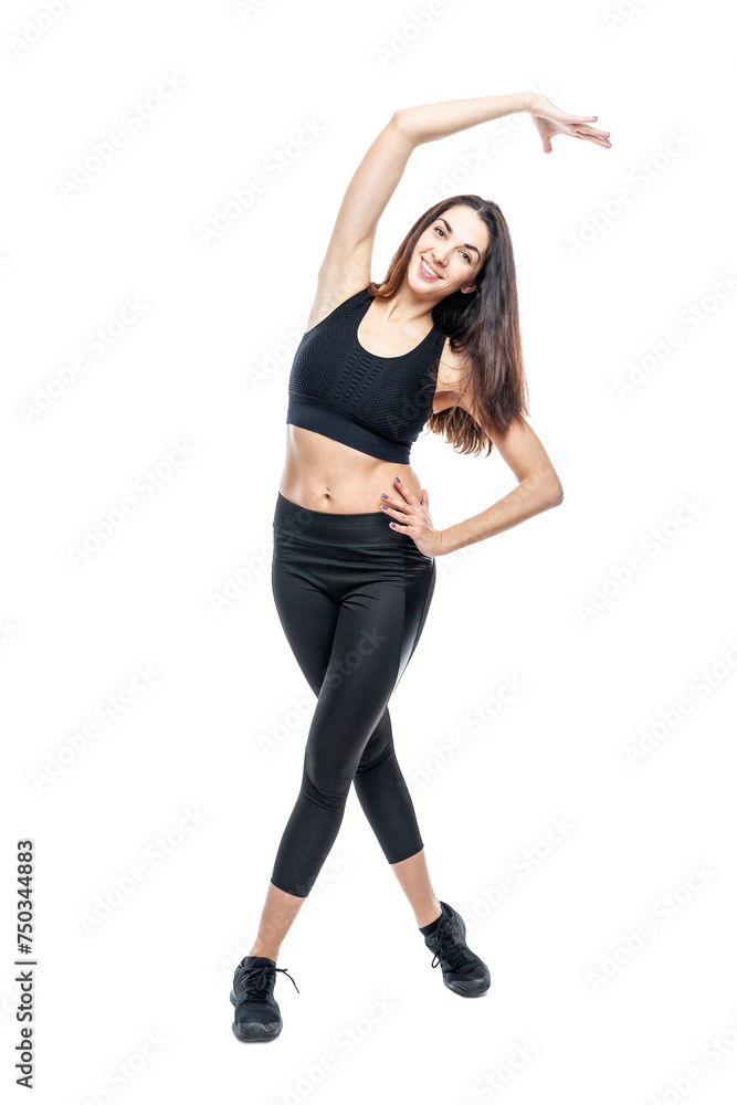 A slender woman in sportswear does exercises. Beautiful brunette in black leggings and top. Health, sports and slimness. Full height. Isolated on a white background. Vertical. A slender woman in sportswear does exercises. Beautiful brunette in black leggings and top. Health, sports and slimness. Full height. Isolated on a white background. Vertical.