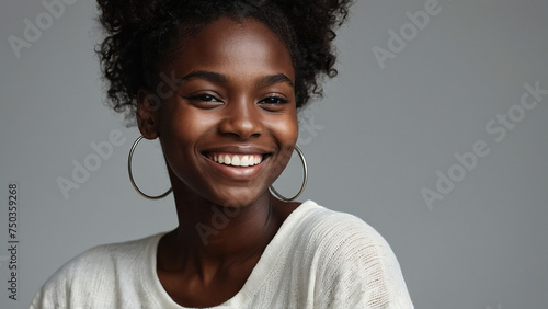 Beauty portrait of african american woman with clean healthy skin on beige background. Smiling beautiful afro girl. Curly black hair photo