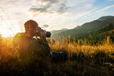 Professional nature photographer in mountain with sunset