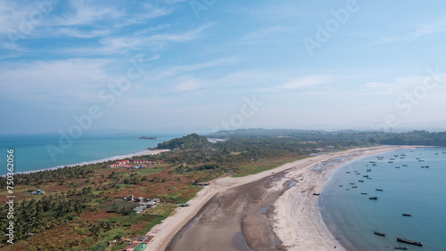 A beach with a small town in the background. Gaw Yin Gyi Island, Myanmar photo