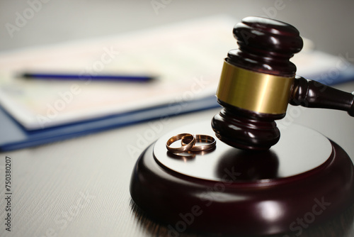 Judge gavel with wedding rings and divorce decree photo