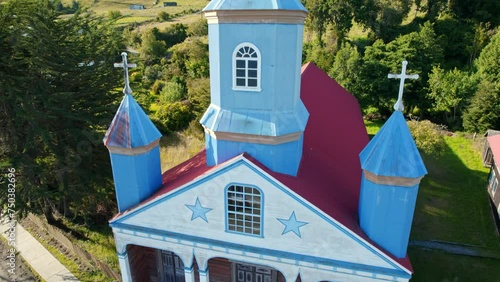 The iconic tenaun church in chiloé, blue spires against green backdrop, unesco site, aerial view photo