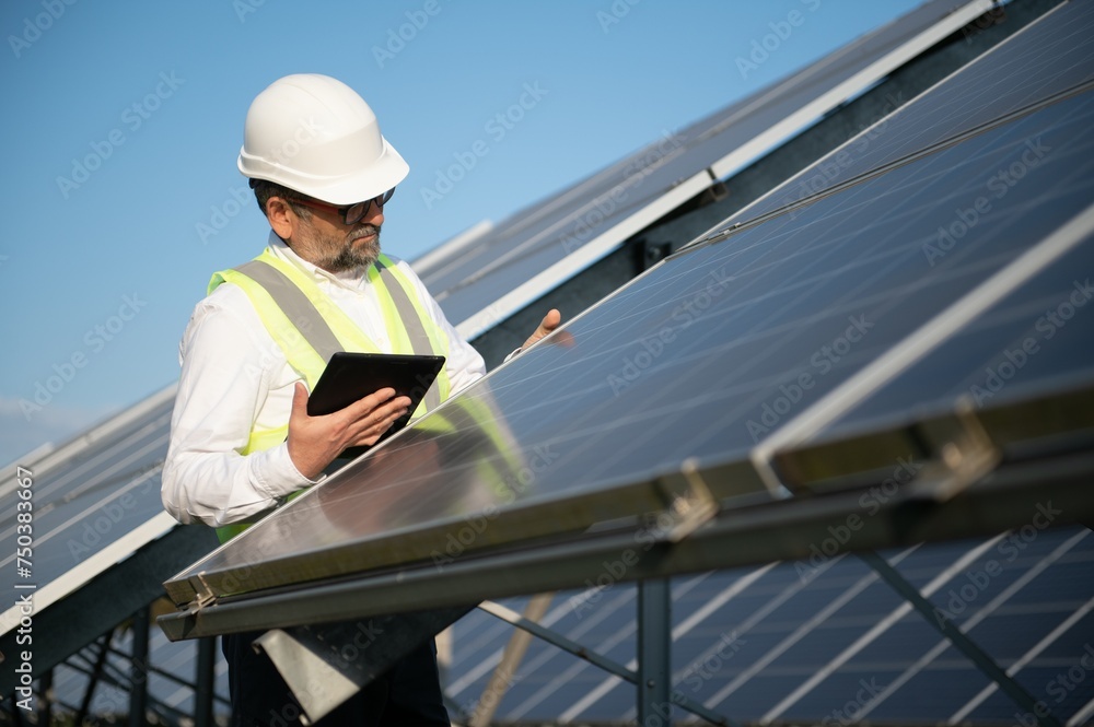 Elderly engineer is checking with tablet an operation of sun and cleanliness on field Elderly engineer is checking with tablet an operation of sun and cleanliness on field