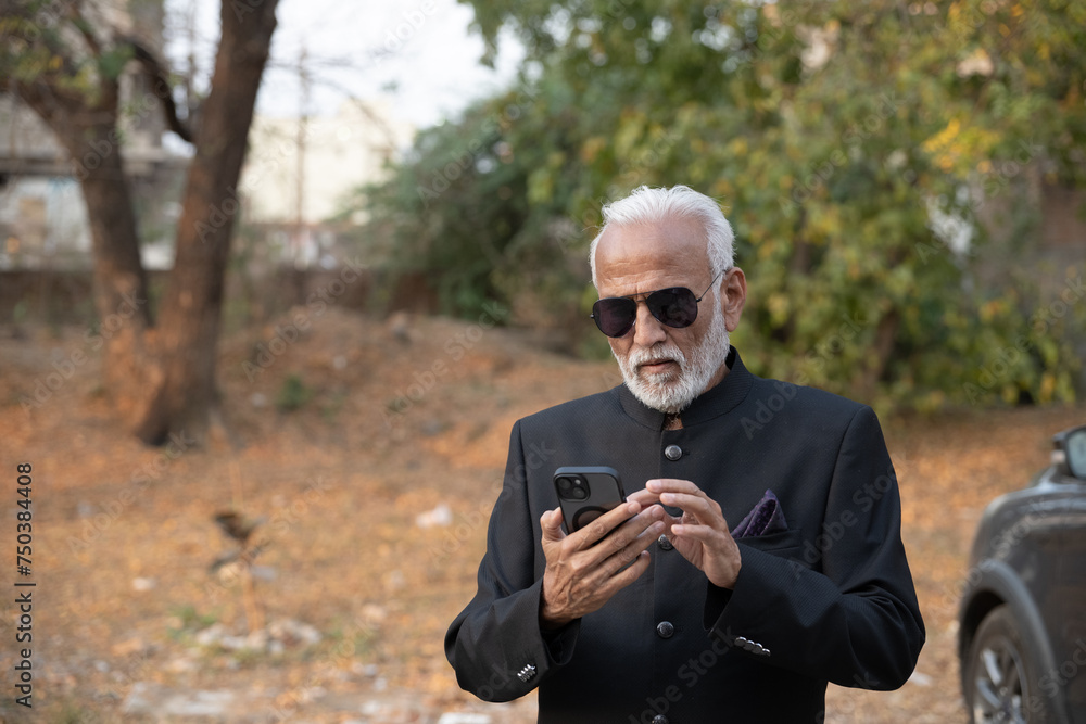 Lifestyle shot of senior Indian man wearing a suit working on a phone Digital India and digitally literate citizens Lifestyle shot of senior Indian man wearing a suit working on a phone Digital India and digitally literate citizens