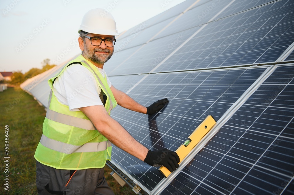Worker installing solar panels outdoors Worker installing solar panels outdoors