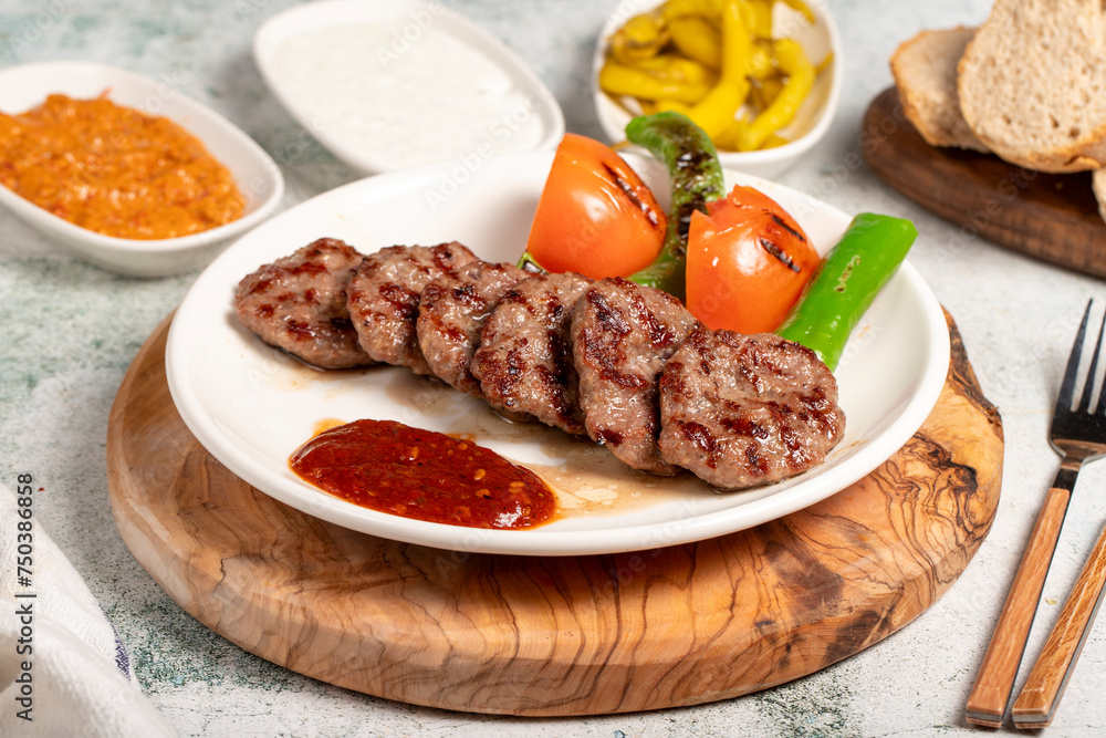 Grilled meat balls. With Tomatoes, Peppers, Appetizers and Special Sauce. Turkish meatballs on a plate Grilled meat balls. With Tomatoes, Peppers, Appetizers and Special Sauce. Turkish meatballs on a plate