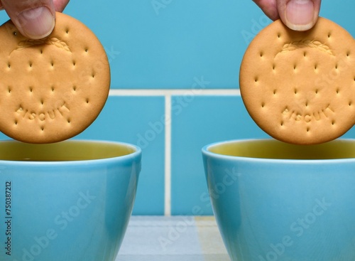 Fényképezés Cups of tea in retro attractive blue and yellow cups with hands and biscuits