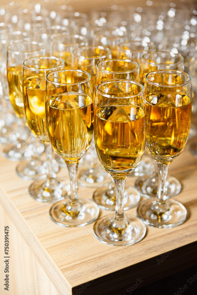 Sparkling Apple Cider Glasses on Wooden Counter. Rows of sparkling apple cider filled glasses on a wooden counter, ready for a festive celebration or toast. Sparkling Apple Cider Glasses on Wooden Counter. Rows of sparkling apple cider filled glasses on a wooden counter, ready for a festive celebration or toast.