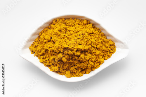 Top View of Organic digestive powder called "Buknu" a mixture of Indian ayurvedic herbs and spices, in a white ceramic bowl. Isolated on a white background.