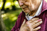 Senior man experiencing chest pain in an outdoor setting, reflecting health concerns and emergency response