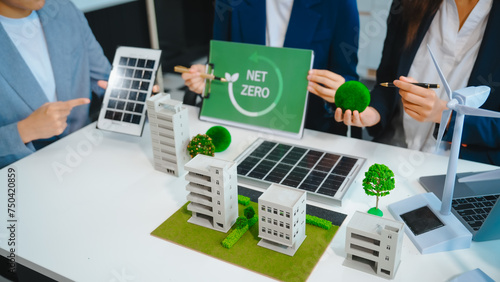 Sustainable business meetings at desks, green energy concepts. People in business suits discussing eco-friendly solutions, solar cells, wind turbines, and promoting net-zero practices.