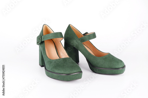 Suede women's green shoes with a strap and buckle on a high thick heel and platform on a white background.Side view.Sale of stylish shoes.Workshop for the repair and care of suede and nubuck shoes. photo