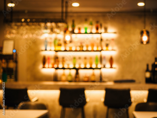 Bar counter with seats Colourful Bottles on shelf Nightclub interior Blur background  © VTT Studio