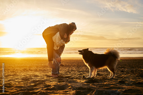 Happy young couple enjoying with dog at beach photo