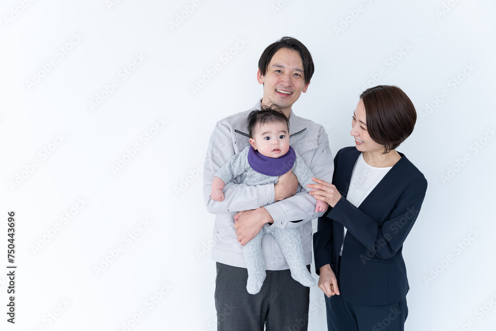 赤ちゃんを抱っこする作業着を着た男性とスーツを着た女性
