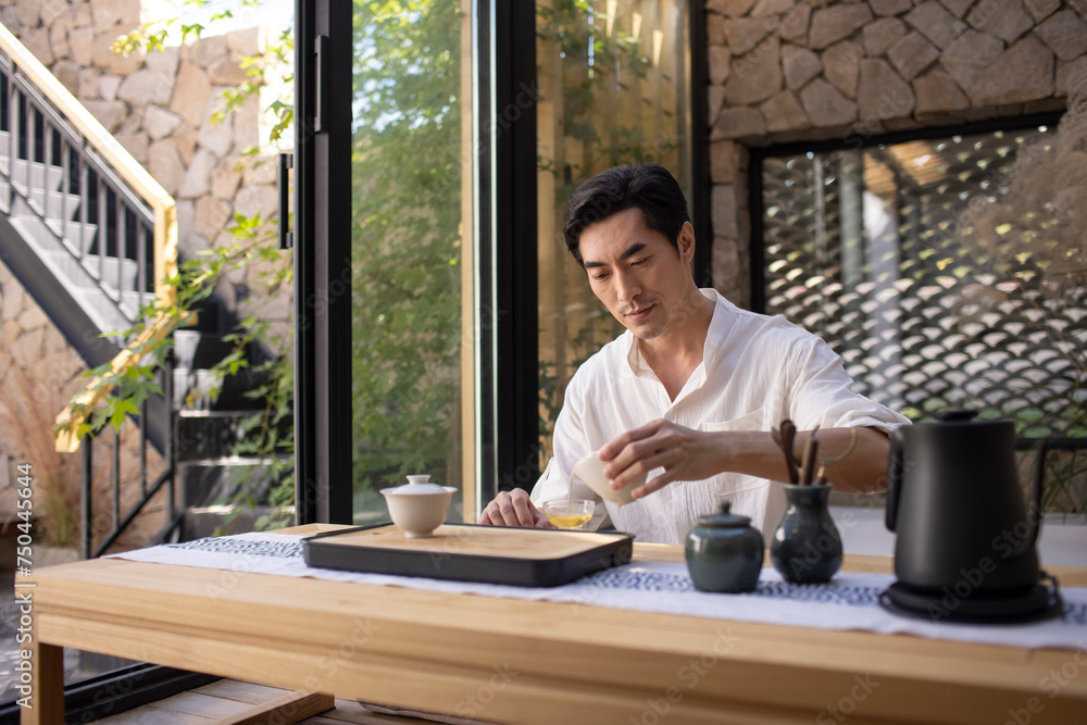 Mid adult man drinking tea in tea room Mid adult man drinking tea in tea room