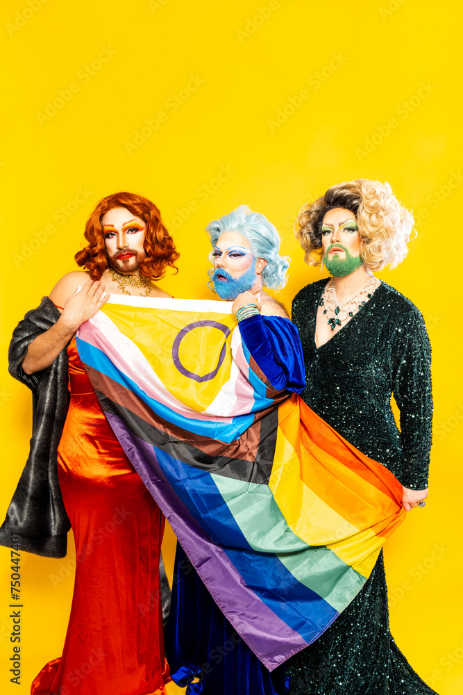 Group of drag queens looking at camera and holding rainbow flag Group of drag queens looking at camera and holding rainbow flag