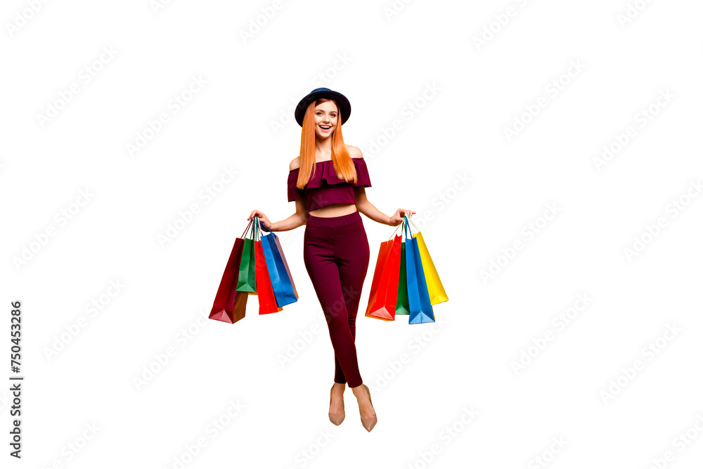 Full length size body portrait of red straight-haired attractive beautiful young girl, wearing spectacles and dark blue hat, suit, pants, holding bags. Isolated over bright vivid yellow background Full length size body portrait of red straight-haired attractive beautiful young girl, wearing spectacles and dark blue hat, suit, pants, holding bags. Isolated over bright vivid yellow background