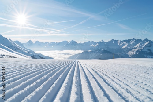 New groomed ski piste or slope. Lines in snow with sunny mountains background. Winter skis concept. 