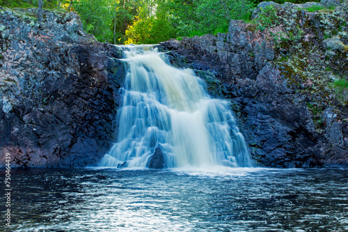 Long exposure of the beautiful Komulank  ng  s Waterfall on Syv  joki river on a warm summer evening in Hyrynsalmi  Finland  Northern Europe