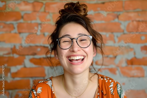 A woman comedy writer smiling widely and wearing glasses in front of the camera.