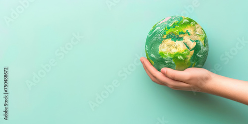 hand holding a green-painted Earth globe on a green background, this image could be used for educational purposes to teach about environmental care or as part of a social media campaign for Earth Day