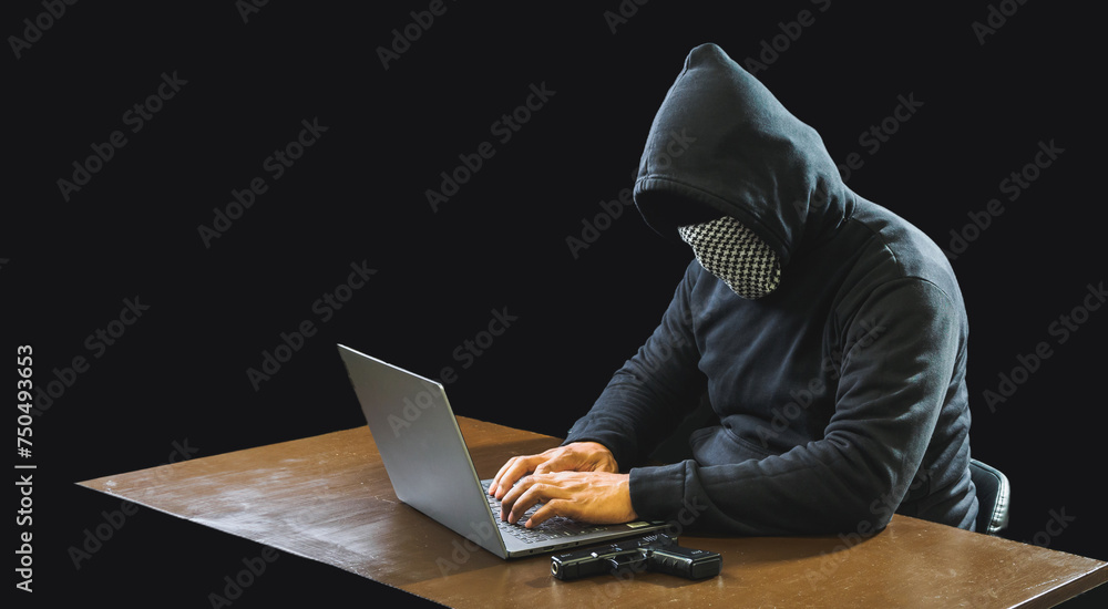 Hand hacker spy man one person in black hoodie sitting on table looking computer laptop used login password attack security to data digital internet network system night dark background copy space Hand hacker spy man one person in black hoodie sitting on table looking computer laptop used login password attack security to data digital internet network system night dark background copy space