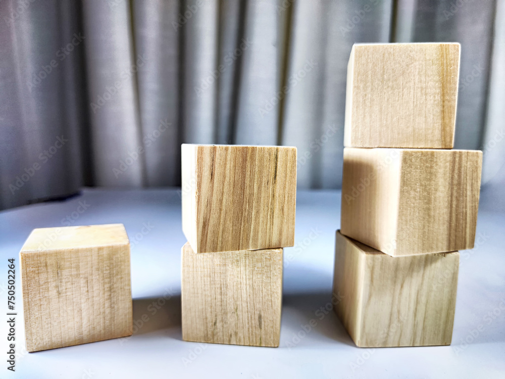 Small wooden cubes in columns, lined up in row. The concept of progressive movement in achieving the goal. Steps and stages of project development and implementation Small wooden cubes in columns, lined up in row. The concept of progressive movement in achieving the goal. Steps and stages of project development and implementation