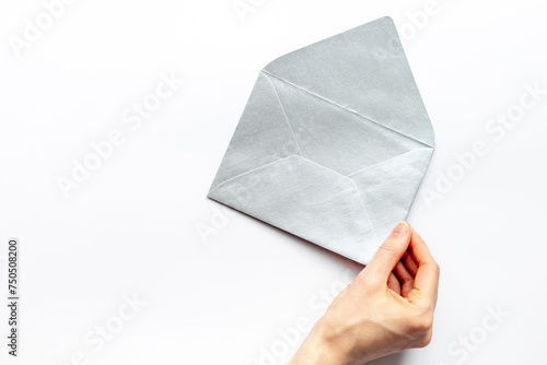 Hand holds blank paper envelope for letters. Space for text, top view