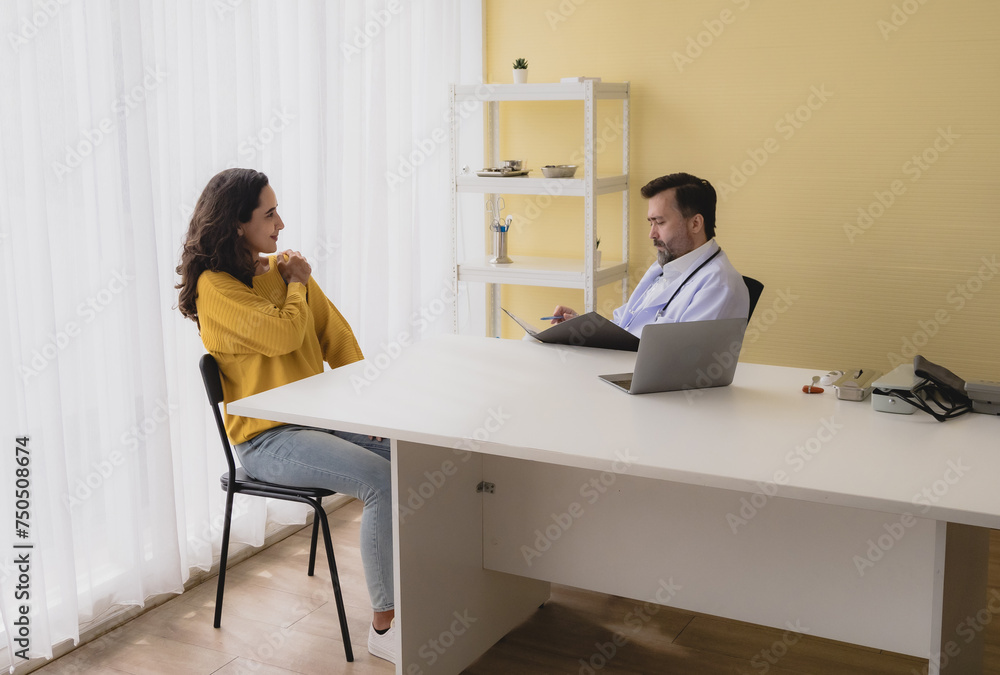 Portrait latin woman sick mentally sit chair with man doctor caucasian sitting two people talk check health and treat patients talk helping support explain medicine sick person inside hospital room Portrait latin woman sick mentally sit chair with man doctor caucasian sitting two people talk check health and treat patients talk helping support explain medicine sick person inside hospital room