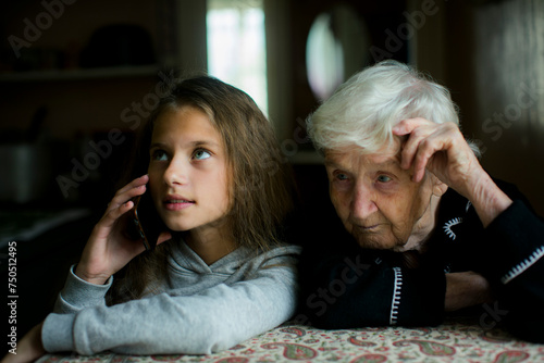 A grandmother listens to her granddaughter talking on the phone.