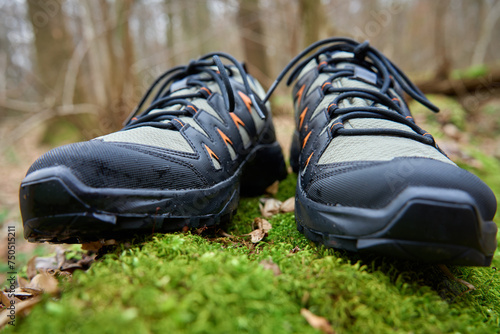 Sturdy hiking boots on vibrant green moss. Trekking shoes in nature. Concept of exploration and outdoor activities