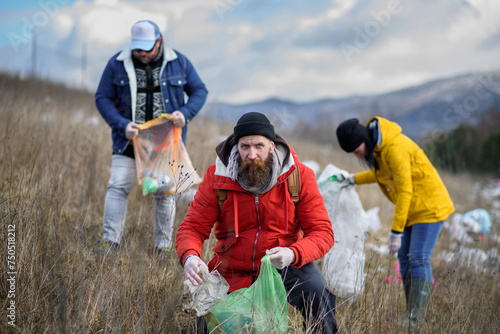 Group of activists picking up litter in nature, environmental pollution, eco activism. and plogging concept.