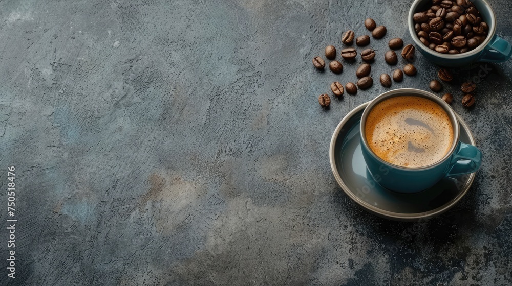 Top view of a freshly brewed espresso in a white cup with scattered coffee beans on a gray surface.