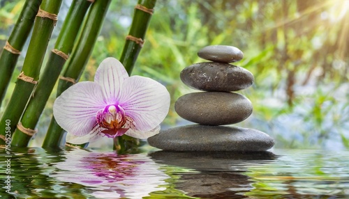 a stack or pyramid of stones bamboo and an orchid in the water balancing pebble stone concept of relaxation equilibrium