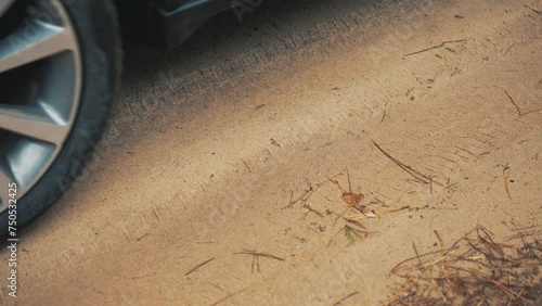 Dirty car rubber tire struggled through sandy road. Vehicle spinning wheel close up. Rotating tyre on dirty road. Automobile offroad photo