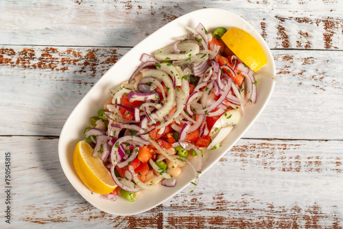 Bean salad. Belarus salad on a wooden background. This salad is made with beans, onion, parsley, chili peppers, sumac, lemon juice and olive oil. Local name piyaz salatasi. Top view photo