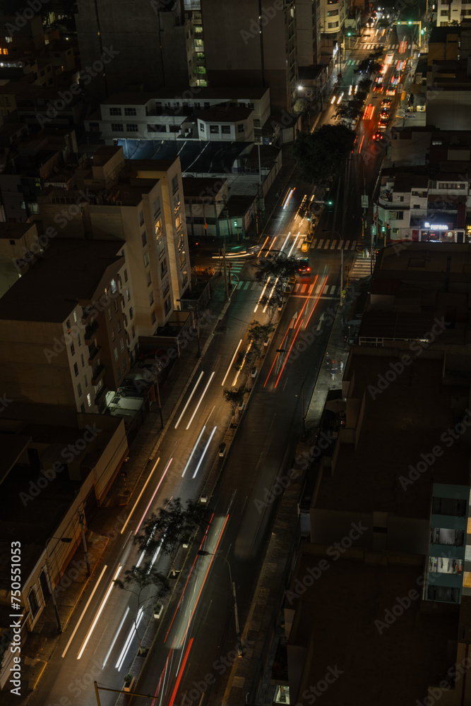 Aerial view Traffic speeds through an intersection at night on a main road. long exposure