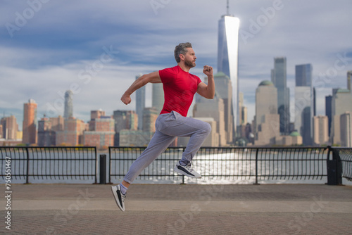 Runner. Running man jogging outside in street. Mature man runner and fitness sport models training outdoor near Manhattan in New York. Millennial athlete jogging while having sports training outdoors. © Volodymyr