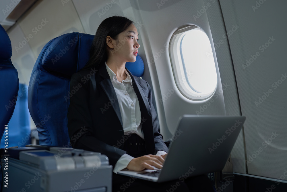 Beautiful Asian businesswoman working with laptop in aeroplane. working, travel, business concept Beautiful Asian businesswoman working with laptop in aeroplane. working, travel, business concept